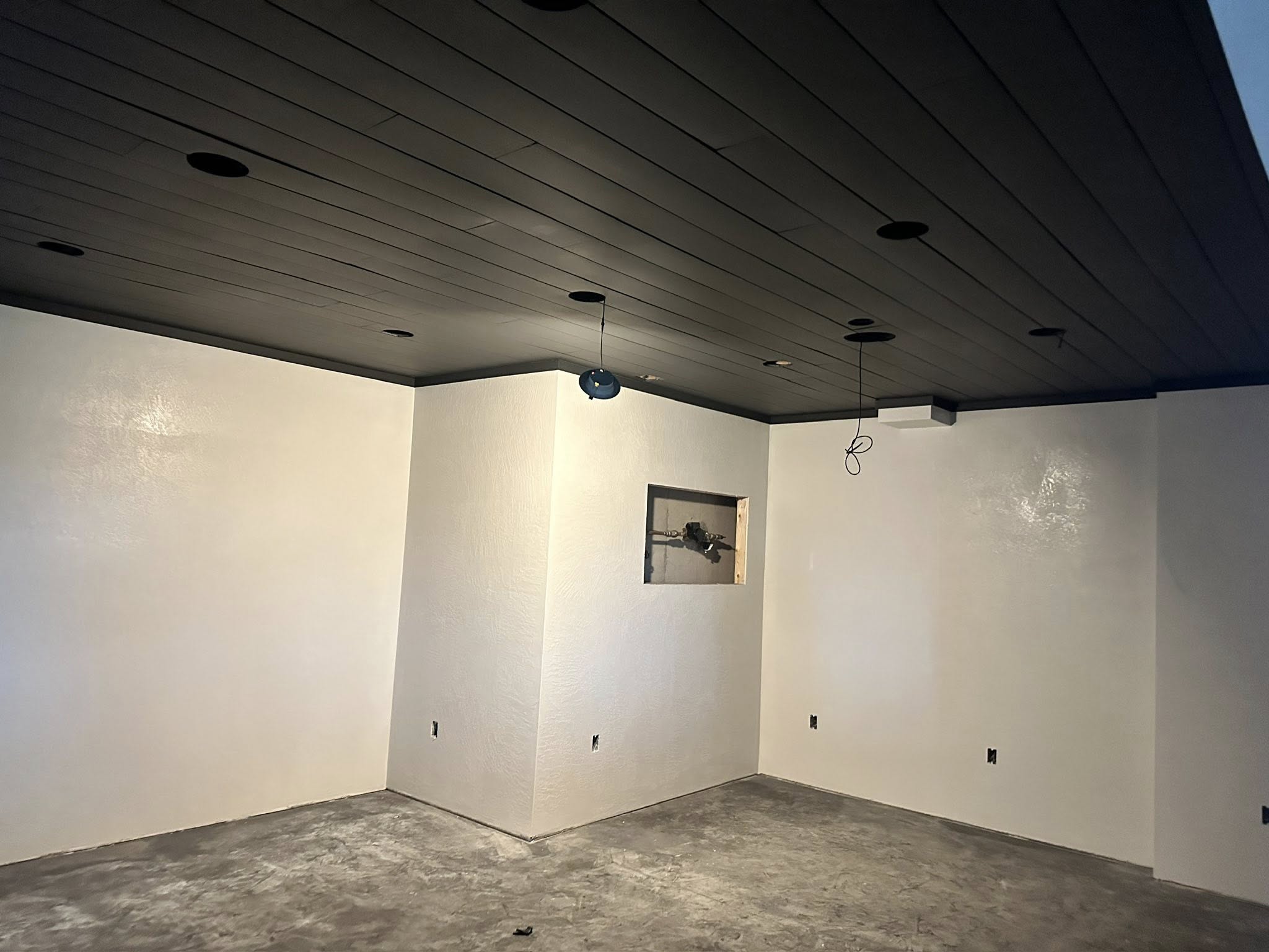Freshly painted interior room with off-white walls and dark ceiling